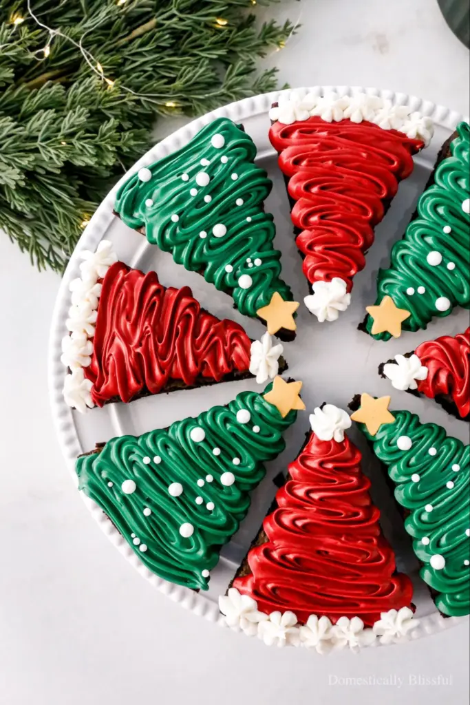Frosted Christmas brownies topped with festive decorations on a holiday plate