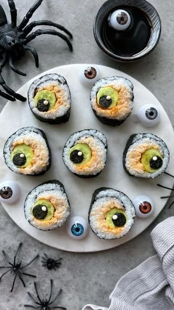 Colorful Halloween Sushi rolls shaped like pumpkins and ghosts.